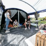 Familie im geräumigen Wohnraum mit einer Stehhöhe von 200 cm im Zelt Montana 8 Sleeper Protect