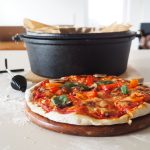 Geschnittene, vegetarische Pizza vor Dutch Oven ohne Füße