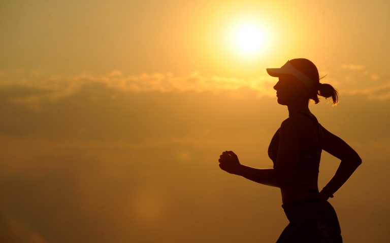 Silhouette einer Läuferin bei Sonnenaufgang