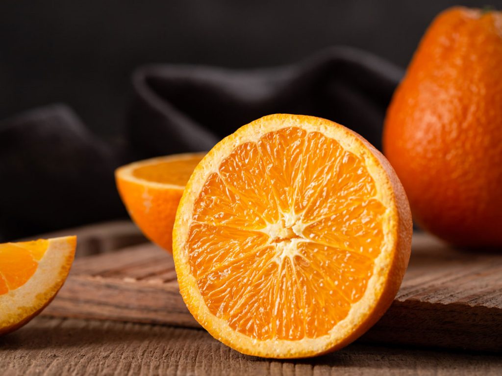 Halbierte Orange auf Holztisch