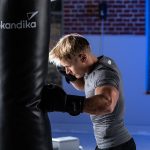 Boxeur s'entraînant sur un sac de frappe avec des gants de boxe Skandika