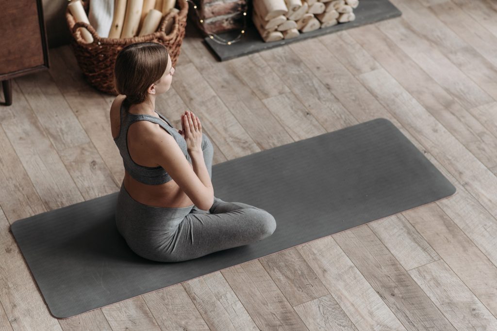 Schwangere Frau auf Fitnessmatte beim Yoga